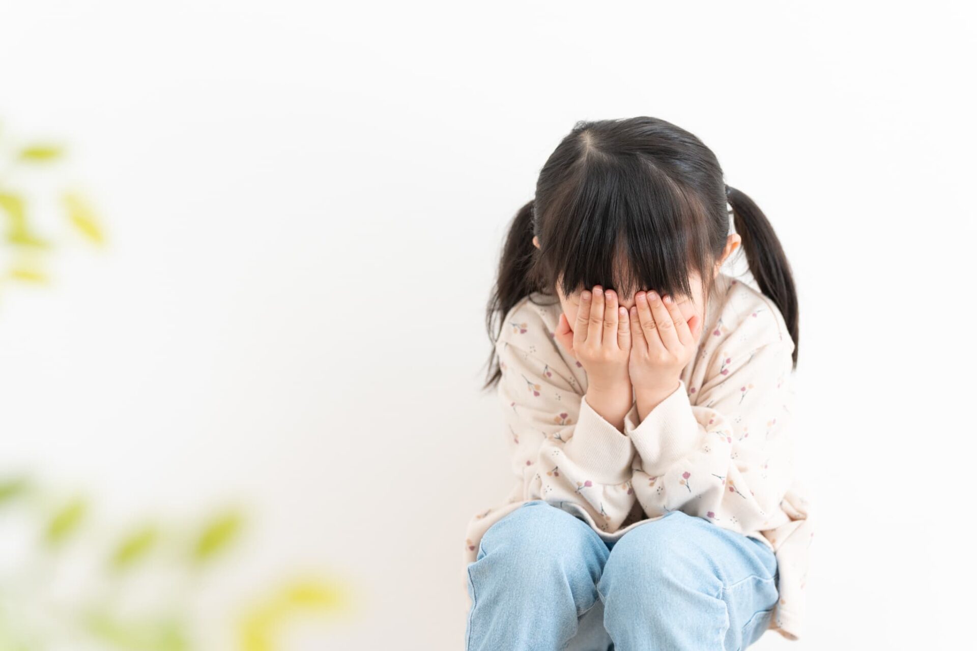 顔を両手で覆って泣く子ども