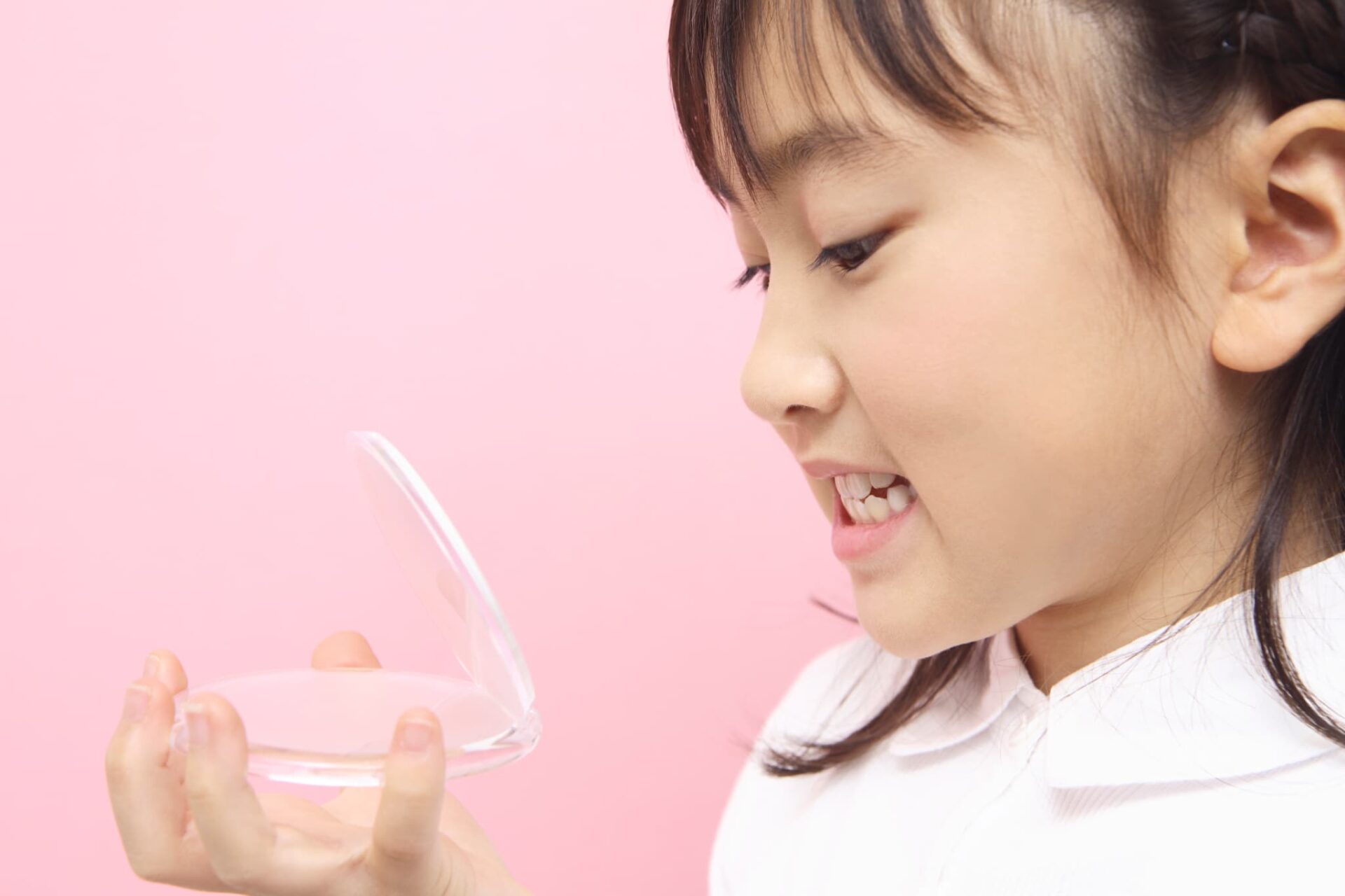 自分の歯並びを鏡で見る子ども