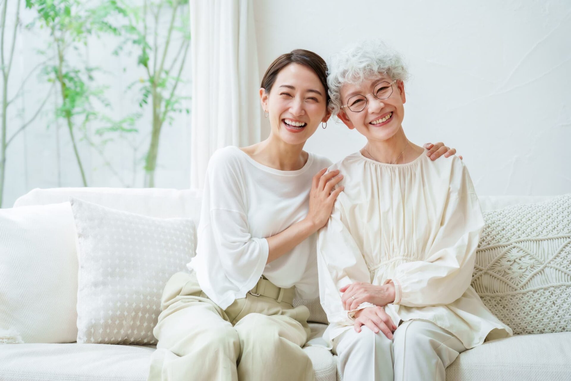 年齢を重ねた母親と笑顔で寄り添う娘