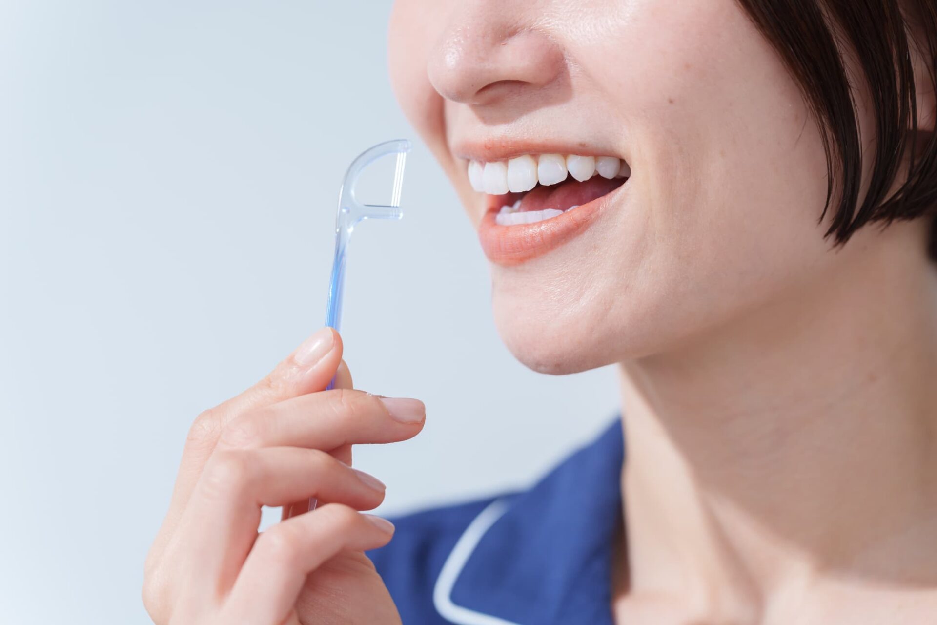 歯周病予防のためデンタルフロスをする女性