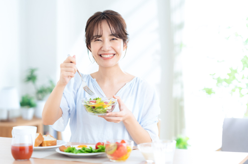 顎関節症が治って笑顔で食事をする女性
