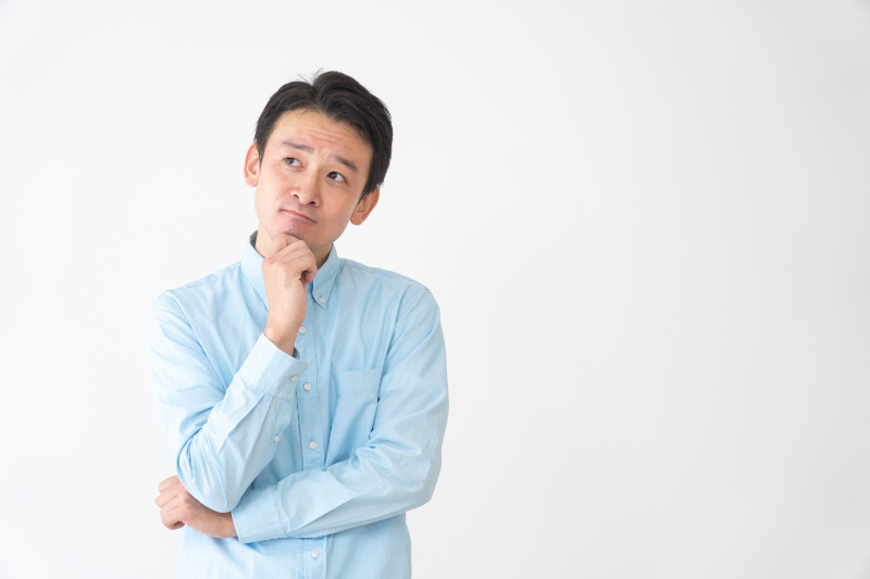 入れ歯が合わない原因について考えている男性