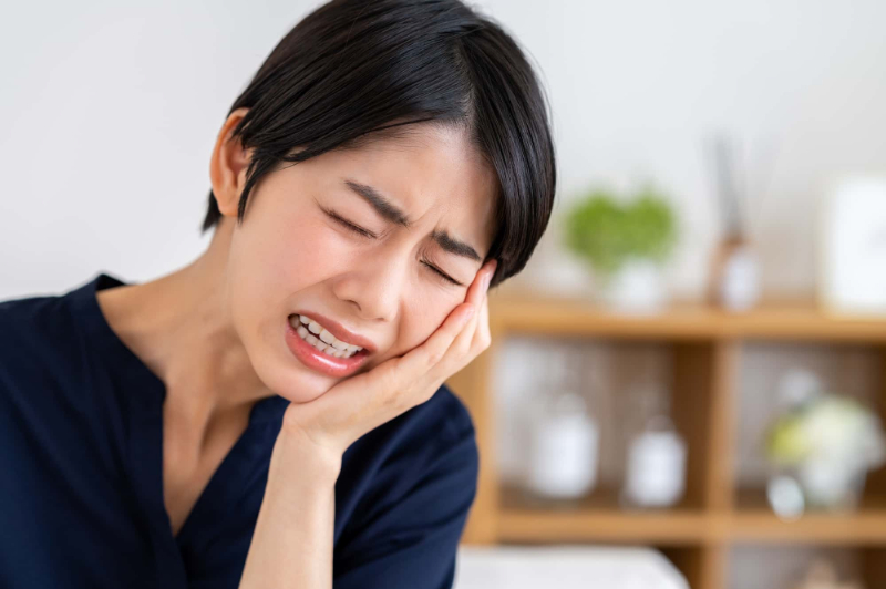 虫歯を放置して激しい痛みに苦しむ女性