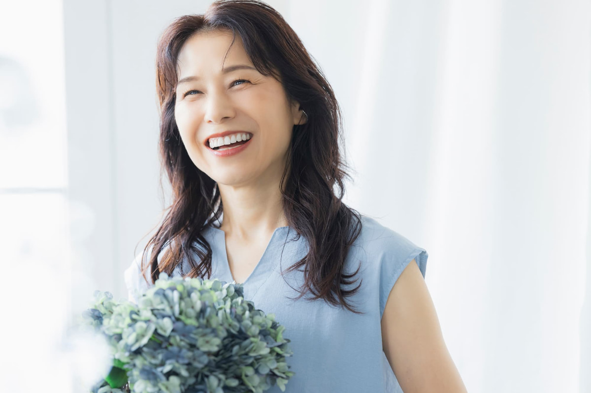 痛みを抑えて歯のクリーニングを無事に受けることができた笑顔のミドル女性
